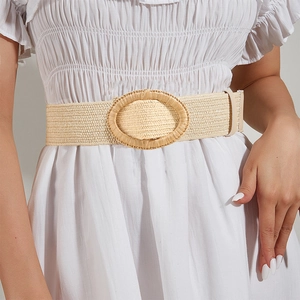 Detail of bohemian wide woven elastic waist belt with large oval raffia buckle
