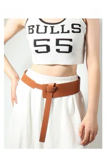 Detail of a brown leather wide waist belt with a vintage knot buckle on a model