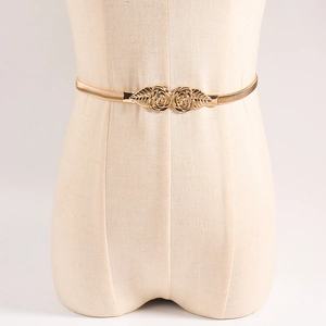 Close-up of golden spring belt with vintage double rose buckle on dress mannequin