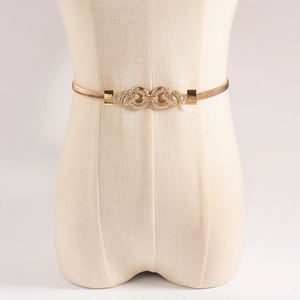 Close-up of golden elastic metal spring belt with interlaced circular buckle on mannequin