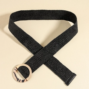Detail of black woven elastic belt featuring a round gold leopard resin buckle on beige
