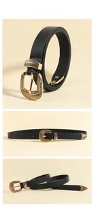 Detailed view of women black leather belt with carved golden buckle and metal tip accents