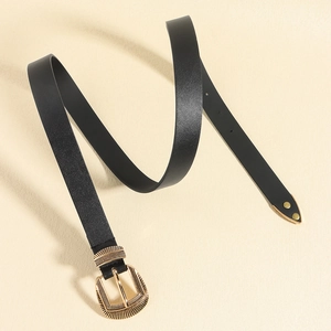 Detail of black leather belt featuring a vintage gold buckle with radial engraving