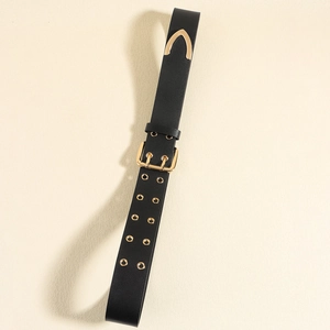 Detail of black leather belt with gold pin buckle, double eyelets and metal tip end
