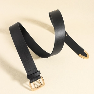 Detail of black leather belt featuring golden double-pin buckle and metallic tip accent