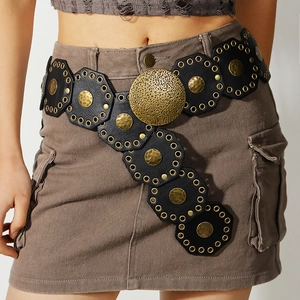 Detail of vintage bohemian wide belt with gold hammered metal discs on black leather