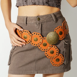 Detailed view of bohemian wide belt featuring orange leather blocks and brass embossed disks
