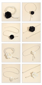 Detailed view of elegant pearl waist chains featuring black and white camellia fabric flowers