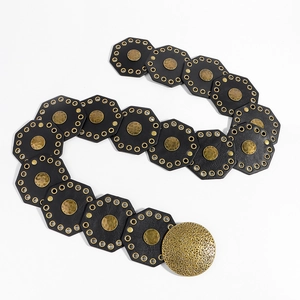 Detail of vintage wide waist belt featuring textured metal discs and leather links