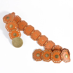 Detail of vintage orange leather belt with octagonal links and large hammered metal buckle