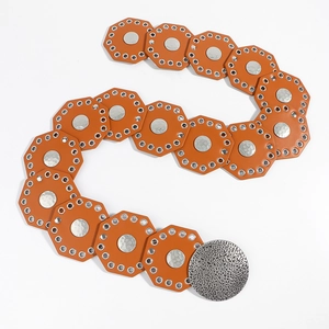 Detail view of orange wide belt with silver rivets and textured metal round buckles