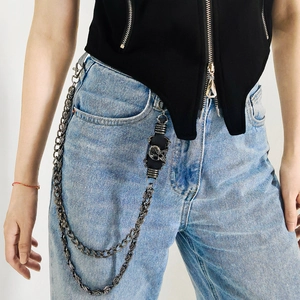 Detail of punk style double-layered trousers chain with skull leather strap on denim
