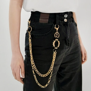 Detail einer zweilagigen goldenen Punk-Hosenkette mit Metallspikes an schwarzer Jeans