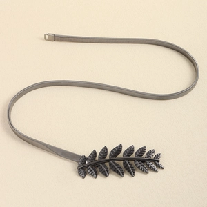 Détail de ceinture chaîne serpent en métal gris foncé avec boucle en forme de feuilles