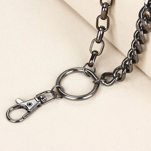 Detail eines gun-schwarzen Karabinerverschlusses und grober Gliederkette für Punk-Hosen