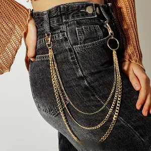 Detail of three-layer gold metal hip hop waist chains on black denim jeans