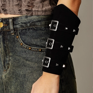 Detail of a black punk leather wrist guard featuring three silver metal buckles and studs