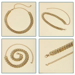 Vue macro d'une ceinture chaîne dorée ornée de strass blancs et d'un fermoir mousqueton