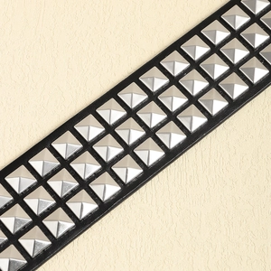 Vue macro détaillée d'une ceinture noire Y2K avec trois rangées de clous argentés