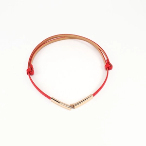 Detail of red slim belt with golden metal buckle and adjustable side knots for women