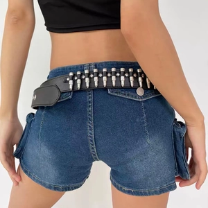 Détail de la ceinture noire Y2K avec rivets métalliques argentés sur short en jean