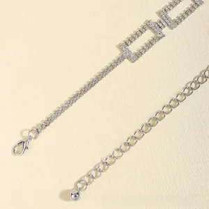 Detailed macro view of silver rhinestone chain with lobster clasp and adjustable metal bead