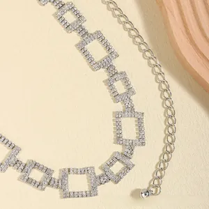 Macro detail of silver waist chain with square zircon links and adjustable ball pendant