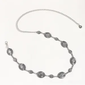 Macro detail of Bohemian silver waist chain featuring etched oval and round metal charms