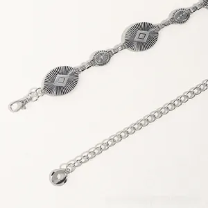Detail of vintage silver boho waist chain with sunburst textured oval metal plates
