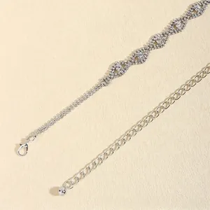 Ceinture chaîne argentée élégante avec maillons strass ondulés et fermoir mousqueton