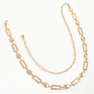 Detail of a double-layered gold metal waist chain with geometric shapes and mirror finish