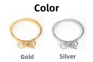 Detail of gold and silver elastic bow metal belts with textured finish on white background