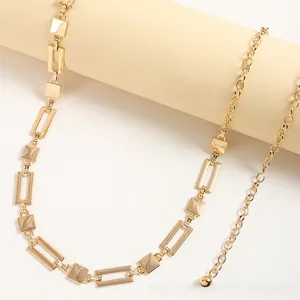 Detail of a gold geometric metal waist chain with polished rectangular links for women