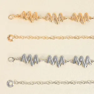 Détail de ceintures élégantes en métal doré et argenté avec fermoirs mousquetons réglables