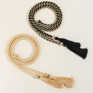 Détail d'une ceinture tressée à glands avec perles dorées en noir et champagne