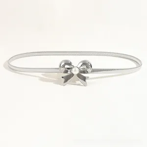 Close-up of silver metal elastic waist belt with bow buckle and pearl center detail