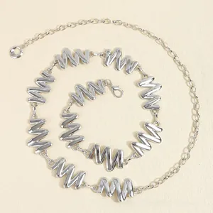 Vue macro de la chaîne de taille en métal argenté poli avec maillons ondulés et fermoir