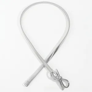 Detail of silver elastic metal mesh belt featuring a decorative hollow bow buckle