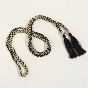Détail d'une ceinture tressée avec des glands en soie noire et des perles dorées