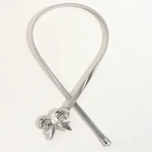 Elegant silver metal spring waist belt with a bow buckle and pearl detail for dresses