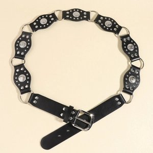 Détail d'une ceinture western en similicuir avec patchs ovales, anneaux et rivets gravés