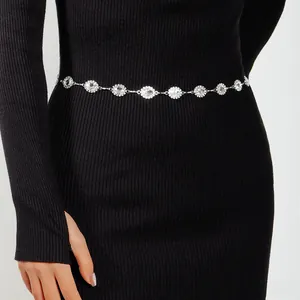 Detailed close-up of a silver daisy rhinestone waist chain on a black dress