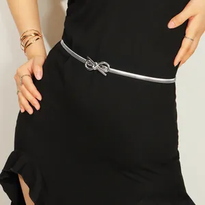Detail of silver elastic metal bow belt on a black dress with polished finish