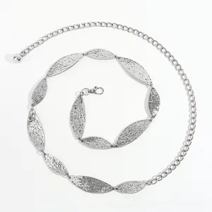 Macro detail of adjustable silver metal leaf belt with hammered texture finish