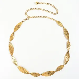 Detailed close-up of golden metal leaf belt with hammered texture and adjustable chain link
