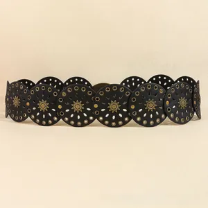 Dettaglio cintura bohemian con dischi neri in pelle e rivetti in bronzo con motivo sole