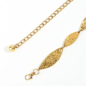 Close-up of golden leaf-shaped metal chain with hammered texture and lobster clasp