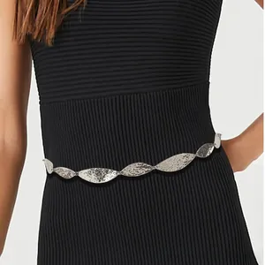 Close-up of silver metal leaf waist chain with hammered texture on black dress