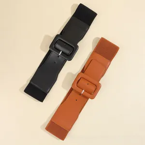 Detail view of black and brown elastic waist belts with leather covered square buckles