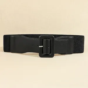 Close-up of black elastic wide belt featuring vintage square buckle and faux leather detail